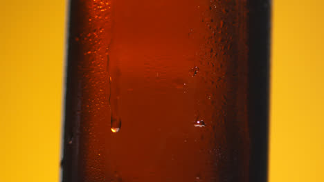 Pull-Focus-Shot-Of-Condensation-Droplets-Running-Down-Side-Of-Revolving-Bottle-Of-Cold-Beer-Or-Soft-Drink-With-Copy-Space